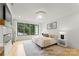 Airy main bedroom with hardwood floors, and black trim windows at 4142 Pineview Rd, Charlotte, NC 28211