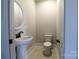 Bathroom features toilet and modern sink with a round mirror at 1405 Coppergate Dr, Salisbury, NC 28147