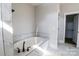 Bright bathroom features a luxurious soaking tub with marble tile surround at 1405 Coppergate Dr, Salisbury, NC 28147