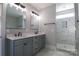 Bathroom with gray vanity, double sinks, framed mirrors and a tiled walk-in shower at 1405 Coppergate Dr, Salisbury, NC 28147