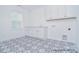 Bright laundry room features designer tile flooring, storage cabinets, sink, and a window at 106 Windbluff Ct # 163, Statesville, NC 28677