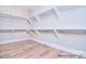 Bright walk-in closet with custom shelving and ample storage space, complemented by stylish wood-look flooring at 106 Windbluff Ct # 163, Statesville, NC 28677