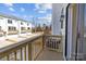 Wooden balcony overlooking townhomes with garages, driveways, and a grassy treeline at 4210 Alexander View Dr # 38, Charlotte, NC 28226