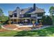 Expansive backyard featuring a stone patio, outdoor kitchen, and mature landscaping at 525 Lake Lynn Rd, Concord, NC 28025