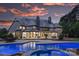 Back exterior of home at dusk showcasing the pool and spa with lights on, and the multiple patios at 525 Lake Lynn Rd, Concord, NC 28025