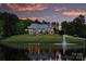 Elegant home with a picturesque lake view, reflecting lights, and surrounded by landscaped grounds at twilight at 525 Lake Lynn Rd, Concord, NC 28025