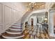 Elegant foyer features curved staircase, ornate chandelier, and decorative wood flooring leading into living spaces at 525 Lake Lynn Rd, Concord, NC 28025