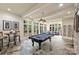 Sunlit game room featuring a billiards table, stone floors, and a comfortable lounge area at 525 Lake Lynn Rd, Concord, NC 28025