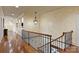 Upstairs hallway with hardwood floors and decorative lighting fixtures with staircase views at 525 Lake Lynn Rd, Concord, NC 28025