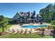 Expansive backyard with a stunning stone house, a sparkling pool, and ample seating for luxurious outdoor living at 525 Lake Lynn Rd, Concord, NC 28025