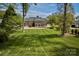 Expansive backyard featuring a lush lawn, mature trees, and brick home with lots of windows at 218 Fairway Dr, Shelby, NC 28150