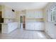 A bright eat-in kitchen features white cabinets, a tile floor, and an entrance to another room at 218 Fairway Dr, Shelby, NC 28150