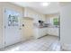 A bright eat-in kitchen features white cabinets, tile floors, a window, and a door at 218 Fairway Dr, Shelby, NC 28150