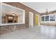 A sunroom with brick walls and tile floors views into the living room with fireplace at 218 Fairway Dr, Shelby, NC 28150