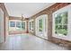 A sunroom with brick walls and tile floors features three large windows at 218 Fairway Dr, Shelby, NC 28150