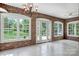 A sunroom with brick walls and tile floors features three large windows at 218 Fairway Dr, Shelby, NC 28150