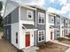 Modern two-story townhome with gray and white siding, red door, and landscaping at 2129 Acclaim St, Charlotte, NC 28205