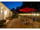 Charming patio area with a round table, chairs, ambient lighting, and lush landscaping at 796 Cornelius Rd, Mooresville, NC 28117