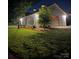 Night view of a barn featuring exterior lights, a gray roof, and attractive landscaping at 796 Cornelius Rd, Mooresville, NC 28117