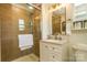 Well-lit bathroom with tiled shower, glass door, tan walls, and vanity with sink and storage at 796 Cornelius Rd, Mooresville, NC 28117
