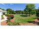 Expansive front yard featuring lush green grass, mature trees, and landscaped flower beds at 796 Cornelius Rd, Mooresville, NC 28117