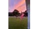 Picturesque front yard view with manicured lawn, American flag, and a vibrant sunset backdrop at 796 Cornelius Rd, Mooresville, NC 28117