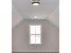 Bright attic space featuring a vaulted ceiling, neutral paint, and a large window at 1108 Piper Meadows Dr # 52, Waxhaw, NC 28173