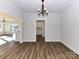 Open dining room with wood floors, a chandelier, and views into the kitchen area at 1108 Piper Meadows Dr # 52, Waxhaw, NC 28173