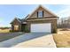 Brick home exterior featuring a two-car garage and manicured landscaping at 1108 Piper Meadows Dr # 52, Waxhaw, NC 28173