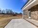 A concrete patio bordered with brick and views of a tree line provides a peaceful outdoor space at 1108 Piper Meadows Dr # 52, Waxhaw, NC 28173