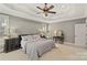 Neutral bedroom features tray ceiling, plentiful light, and carpeted floors at 2012 Tomshire Dr, Gastonia, NC 28056