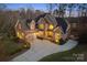 Stunning two-story brick home boasts a large driveway and manicured landscaping with accent lighting at 2012 Tomshire Dr, Gastonia, NC 28056