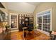 Spacious home office featuring hardwood floors, a glass-top desk, and custom built-in display cabinets with great natural light at 2012 Tomshire Dr, Gastonia, NC 28056