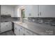 Modern kitchen featuring white cabinets, gray countertops, and stylish backsplash at 1571 Branchville Rd, Shelby, NC 28150