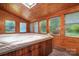 Sunroom with built-in hot tub and wood paneled walls at 1571 Branchville Rd, Shelby, NC 28150