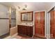 Classic bathroom featuring a walk-in shower, wood cabinets, and a large mirror at 235 Walnut St, Statesville, NC 28677