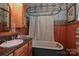 Bathroom features a clawfoot tub with vintage fixtures, wood paneling, and decorative wallpaper at 235 Walnut St, Statesville, NC 28677