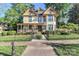 Charming two-story home featuring a covered front porch, colorful accents, and mature trees in a desirable neighborhood at 235 Walnut St, Statesville, NC 28677