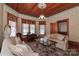 Bright living room featuring large windows, hardwood ceiling, patterned wallpaper, and comfortable sofas at 235 Walnut St, Statesville, NC 28677