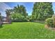 Large backyard with lush green lawn and tall trees at 215 N Main St, Belmont, NC 28012
