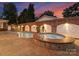 Night view of a pool and hot tub with brick wall at 215 N Main St, Belmont, NC 28012