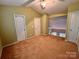 A bright bedroom is shown with neutral walls, carpet, and two closets at 10875 Holly Ridge Blvd, Charlotte, NC 28216