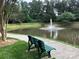 Scenic community pond with a fountain and a park bench on a paved walkway at 10875 Holly Ridge Blvd, Charlotte, NC 28216