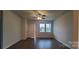 Bright living room with hardwood floors, a ceiling fan, and a view of the front yard through large windows at 2668 Meadow St, Gastonia, NC 28056