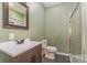 Bathroom features a vanity, toilet, and a shower with glass doors at 159 Badin Lake Cir, New London, NC 28127