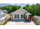 Inviting single-story home with a charming front porch and a concrete driveway nestled among lush trees at 159 Badin Lake Cir, New London, NC 28127