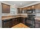Kitchen featuring granite countertops, stainless steel appliances, and dark wood cabinets at 159 Badin Lake Cir, New London, NC 28127