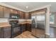 This kitchen features stainless steel refrigerator, microwave and range with wood cabinetry at 159 Badin Lake Cir, New London, NC 28127