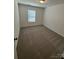 Simple bedroom with neutral carpeting and a window with blinds at 5033 Falstone Dr, Charlotte, NC 28269