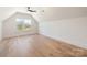 A bedroom with a large window offering a view of the outside, neutral colors, and wood floor at 3945 Plainview Rd, Charlotte, NC 28208